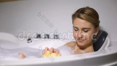 女孩躺在浴缸里，用海绵洗身体，日常美容程序，清新